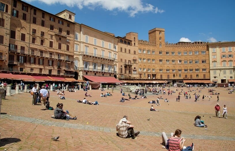 Pessoas sentadas na Piazza del Campo em Siena