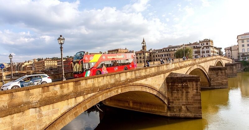 Ônibus turístico passando por ponte em Florença