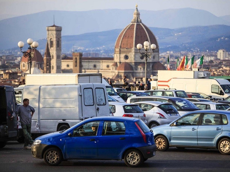Carros estacionados e cidade de Florença de fundo